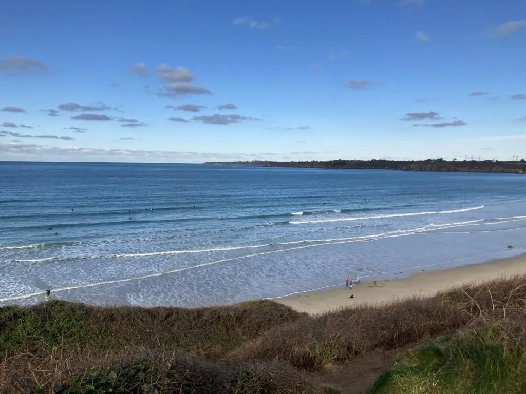 La plage des Blancs Sablons, longue étendue de sable et houle d'hiver, surfeurs au large